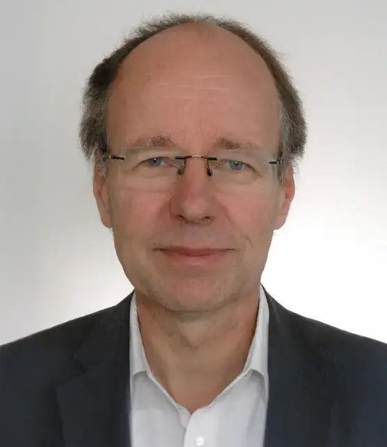 Prof. Dr. Dirk Jäschke Ein Porträtfoto von Herrn Dirk Jäschke, ein Mann mittleren Alters mit Brille und kurzem, lichtem Haar. Er trägt ein weißes Hemd unter einem dunklen Sakko und blickt mit einem neutralen, freundlichen Ausdruck direkt in die Kamera. Der Hintergrund ist schlicht und hellgrau gehalten.